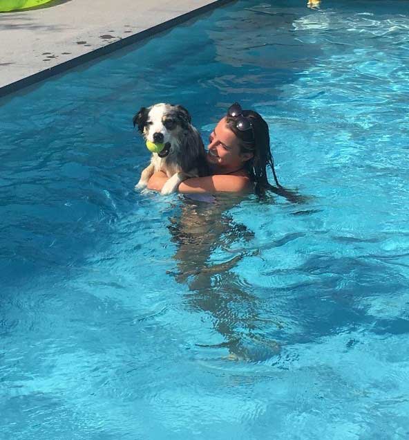Yne met een hond in het zwembad.